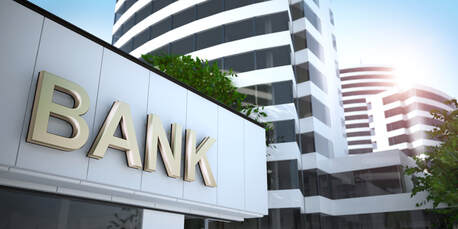Picture of a downtown city with the word bank written in big gold letters