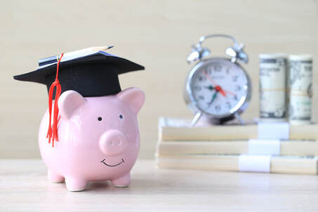 Picture if a piggy bank wearing a graduation cap sitting in front of a stack of money