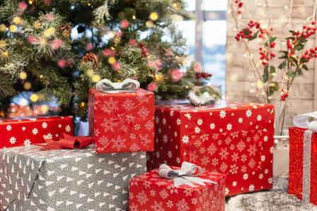 Picture of wrapped Christmas presents placed in front of a decorated Christmas tree