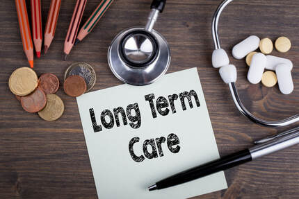 Picture of a post-it note with Long Term Care written on it sitting on a table with a pen, a stethoscope, some pills, some coins, and some colored pencils